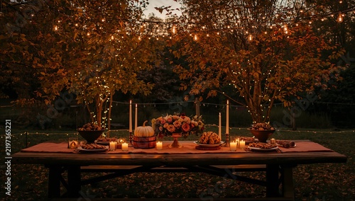Dinner Gathering at a Decorated Outdoor Table With Food and Lights