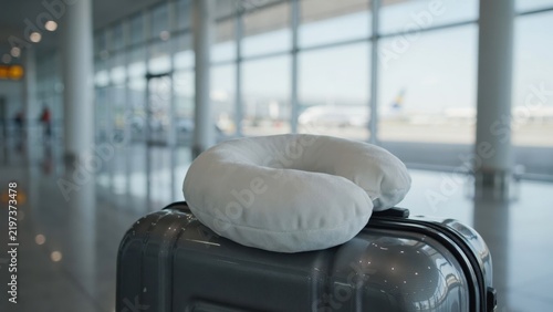 Travel neck pillow on suitcase at airport