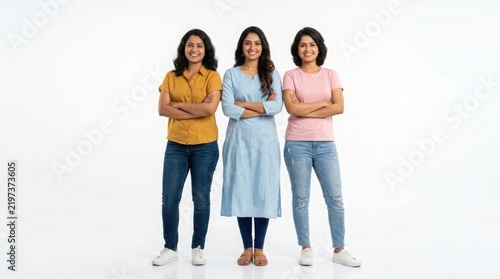 Three empowered indian women confidently pose together for a studio portrait on a plain white backdrop
