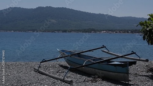 Traditional Outrigger Boats on a Pebble Beach with Mountain Backdrop