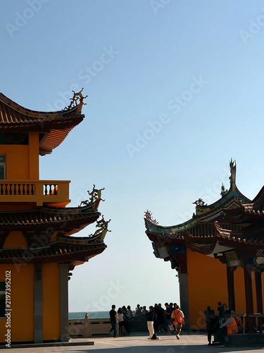 Bild auf Leinwand The multi‑tiered pagoda architecture of Luoga Temple rising dramatically from its rocky offshore island along Shishi’s Golden Coast