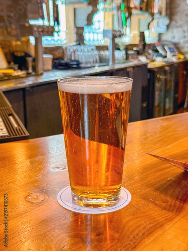 Fotografie Pint of golden lager beer on the top of a bar. No people.