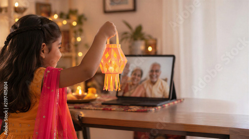 Child celebrating diwali, video calling grandparents with lantern