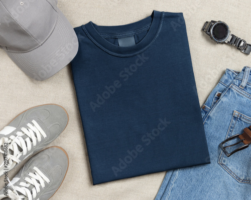 Blank washed navy blue folded unisex t-shirt mockup, crewneck flat lay with jeans and mens accessories