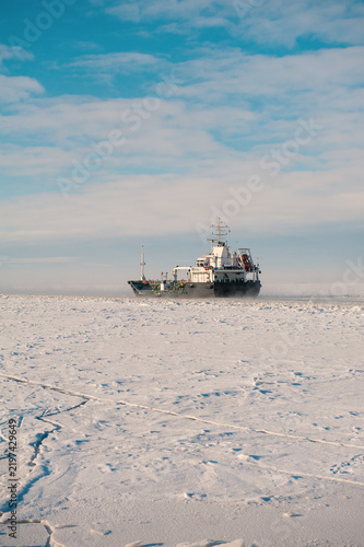 Winter shipping. Big cargo ships in frozen sea fairway