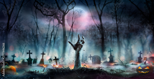 Halloween Zombie - Hands Rising Out Of A Cemetery In Forest At Night With Abstract Bokeh Lights And Defocused Background