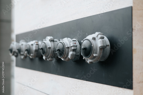 Fotografie A series of decorative knobs are mounted on a black panel, creating a modern design element