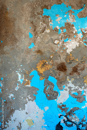 Old peeling wall background with bright blue paint and cracks texture