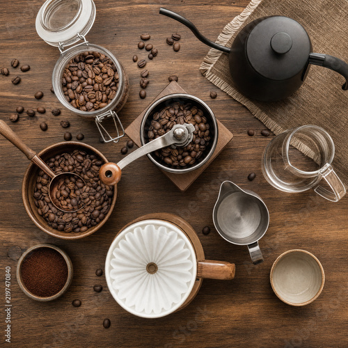 Fotografie Flat lay of coffee beans, manual grinder and brewing tools on wooden table, spec
