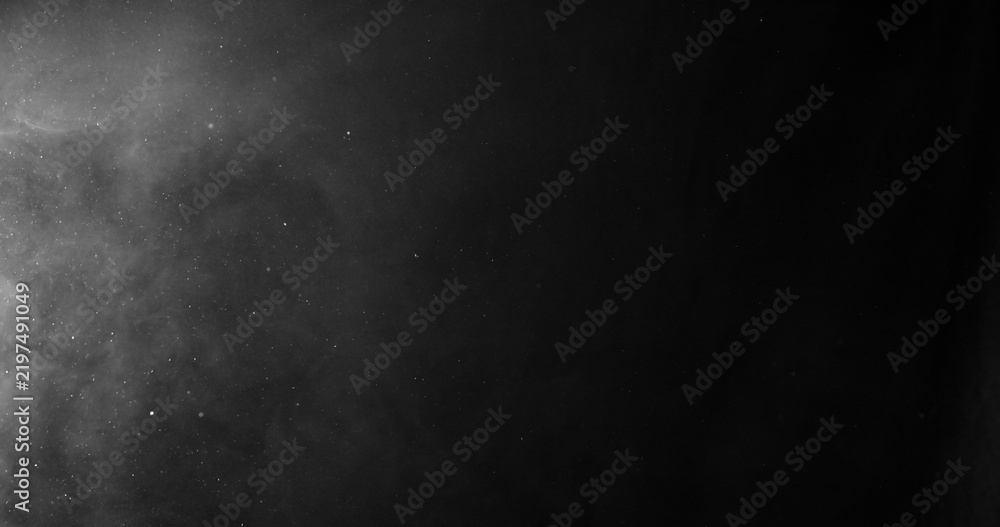 Obraz premium White smoke swirling and dissipating in dark background.
