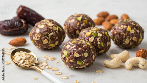 Close-up of assorted energy bites with nuts and seeds on a white surface