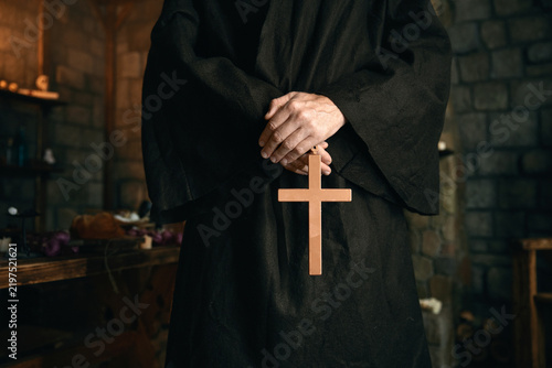 Fotografie Closeup view cropped shot with golden cross in priest monk hands