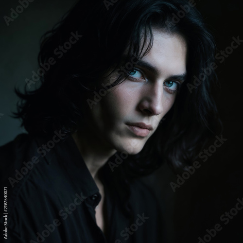 Dramatic Portrait of Young Aristocratic Man with Dark Wavy Hair and Piercing Blue Eyes