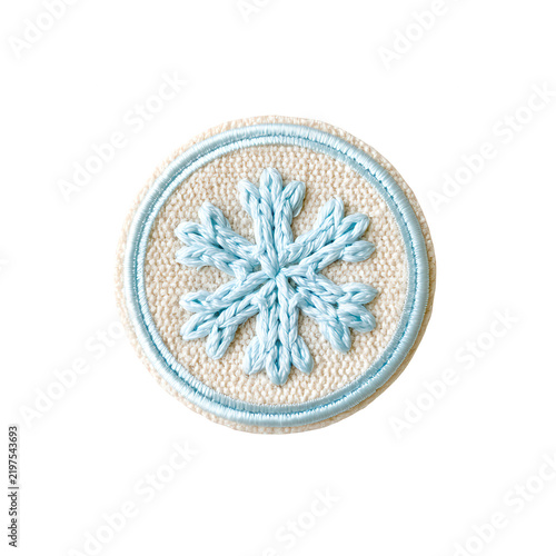 Knitted light blue snowflake patch on beige fabric with clean white background for textile branding