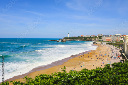 View of sandy beach and white lighthouse at Grande Plage in Biarrits, France