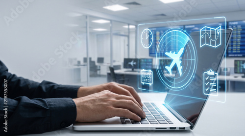 Digital interface showing aircraft flight logistics and tracking data projected over a professional laptop screen during work in a modern office environment using advanced technology