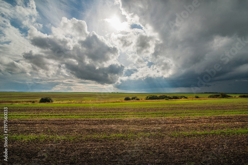 A picturesque rural landscape under a cloudy autumn sky.