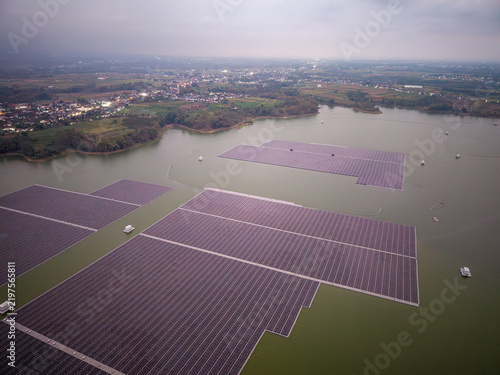Floating solar panels cover vast lake surfaces. Rows stretch across calm waters at Waduk Karangkates