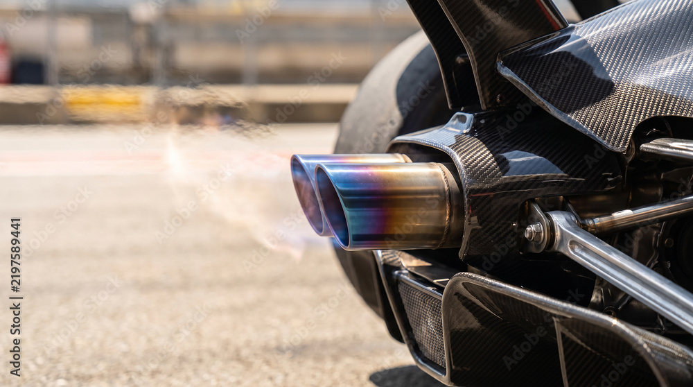 Fototapeta premium Carbon fiber rear exhaust system of supercar on track with heat exhaust.