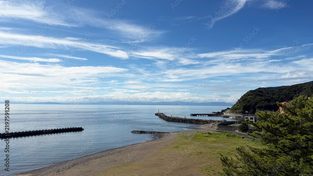 Fototapeta premium 青空と穏やかな海が広がる山あいの静かな海岸風景
