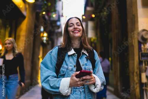 Close up portrait of confident Caucasian female freelancer smiling looking at camera with smartphone, verifying cybersecurity data protection protocols and safe wireless network settings