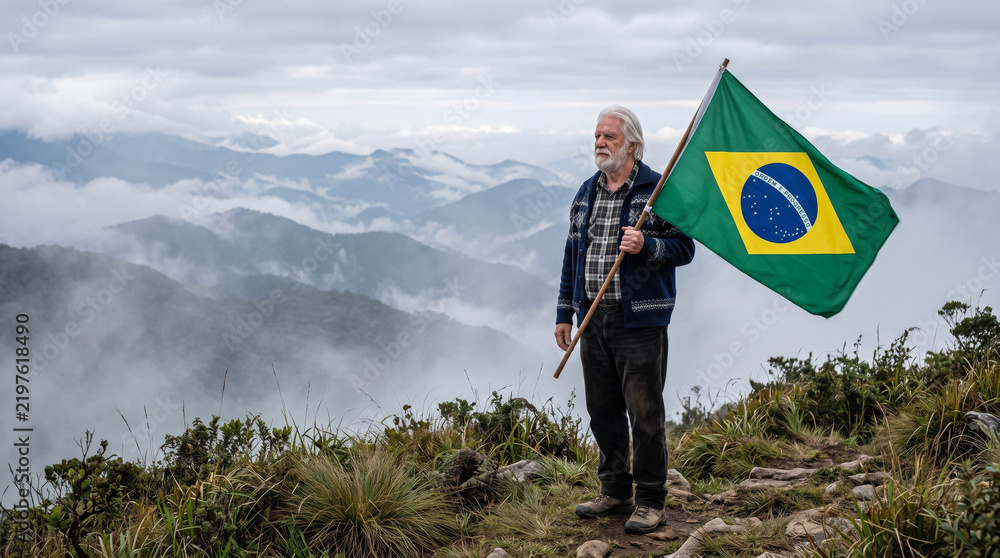 Obraz premium Elderly man holding Brazilian flag on mountain