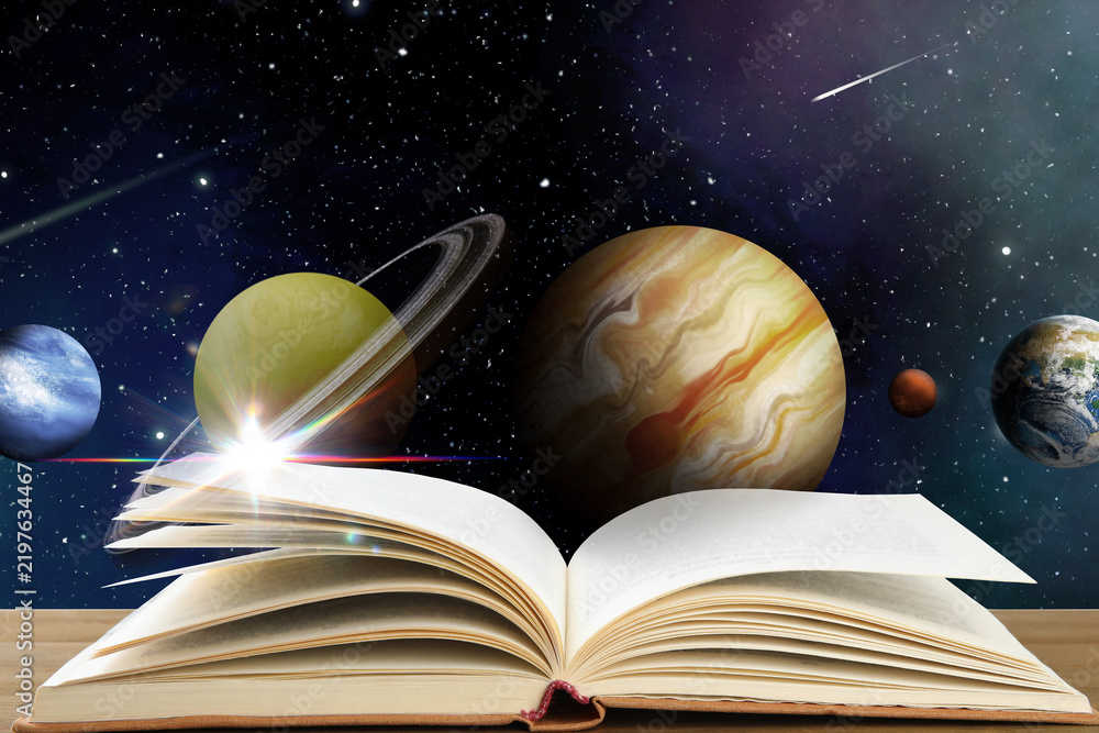 Fototapeta premium Open book on table against space with planets. Wonderful world of fantasy