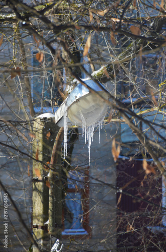 A street lamp covered in icicles in daylight. Winter natural beauty. Frozen precipitation on the lamp fixture.