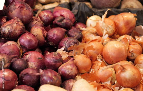 Fresh organic red and yellow onions at market stall