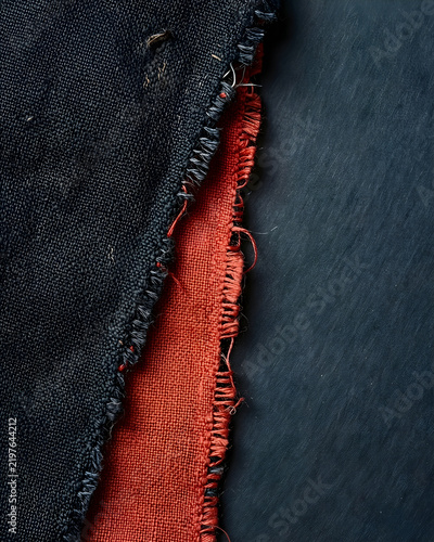 One repaired contrasting patch showing dense visible darning across torn charcoal cloth on coral for design, architecture, craft, premium branding, editorial and material-trend campaign