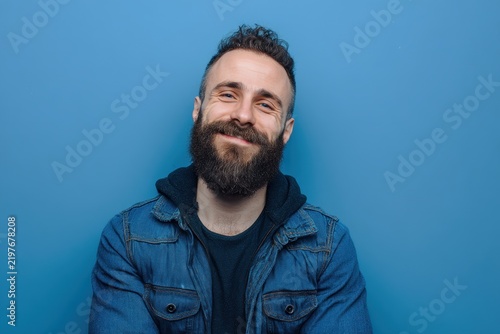 Portrait of a Smiling Bearded Man in a Denim Jacket