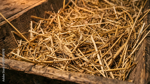Dry Straw Texture Filling a Wooden Box, Rustic Background for Agricultural or Farm Themes. Natural Material, Close-Up Detail, Harvest Concept.