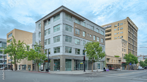 professional commercial real estate photograph of a generic four-story mixed-use building on an ordinary urban street, 