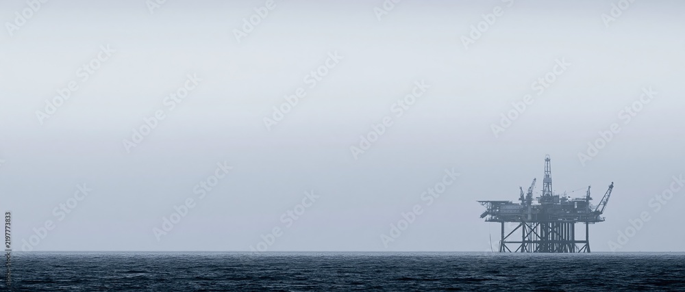 Obraz premium Offshore Oil Rig Platform in a Misty Ocean Horizon, Industrial Energy Production
