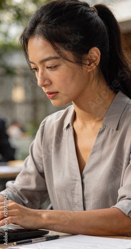 Woman working on laptop outdoors sunlight daytime