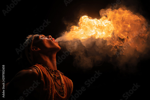 Fire Eater's Spectacle: A performer exhales a powerful stream of fire, creating a dramatic and captivating spectacle against a dark backdrop.
