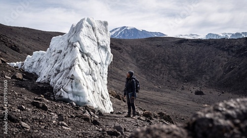 Hiker observing Furtwängler Glacier remnant on Mount Kilimanjaro, Tanzania