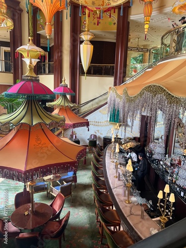 Ornate Hotel Lobby Lounge With Colorful Hanging Parasols, Tropical Plants and Bar Seating