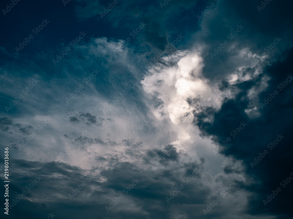 Fototapeta premium Dramatic Cumulus Clouds with Sunlight Breaking Through Blue Sky