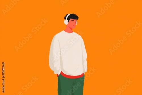 A man wearing a white shirt and green pants with headphones on standing against an orange background.