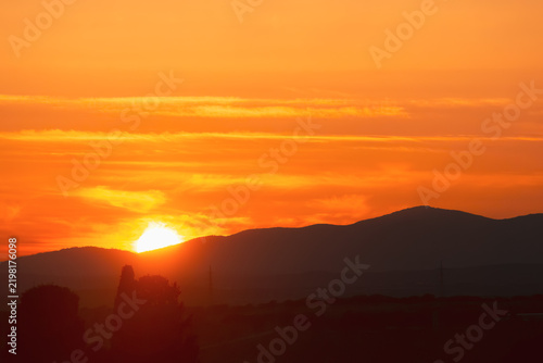 Atardecer en la Sierra de Guadarrama, en Madrid, España. Cielo anaranjado con los últimos rayos de sol resaltando la silueta de las montañas situadas al norte de Madrid.