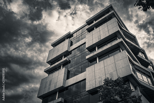 Modernist Building in Black and White Under Dramatic Clouds