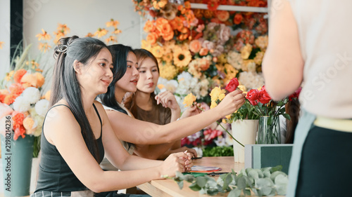 Candid moment group of women arranging flowers in a floral class