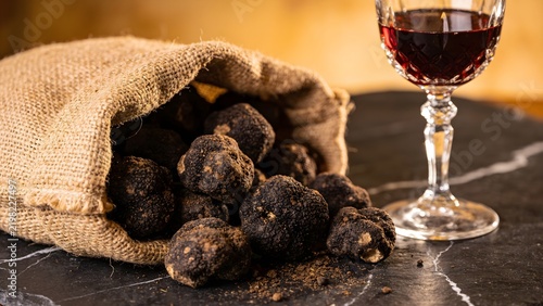 Rustic Foraging Scene with Soil Caked Black Truffles in Burlap Sack Near Glass of Barolo Wine