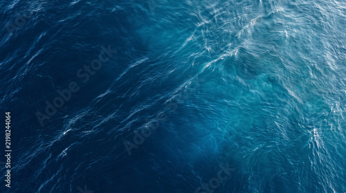 Deep blue ocean water surface background with light ripples and waves