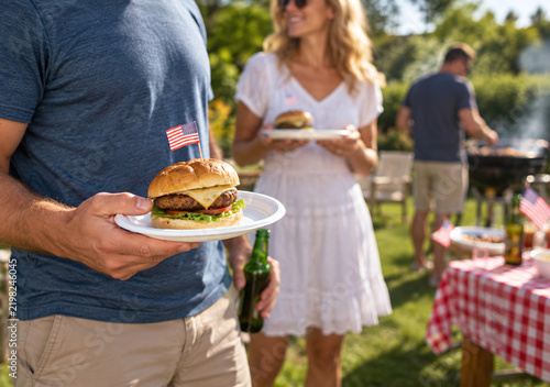 Man Holding Burger with Flag at Backyard Barbecue Party