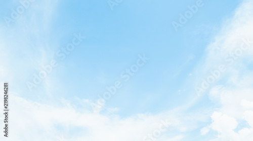 the sky is clear blue with fluffy white clouds, the sky is very bright, and the sun shines.