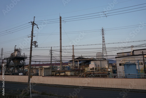 配管とタンクが並ぶ夕暮れの工場設備