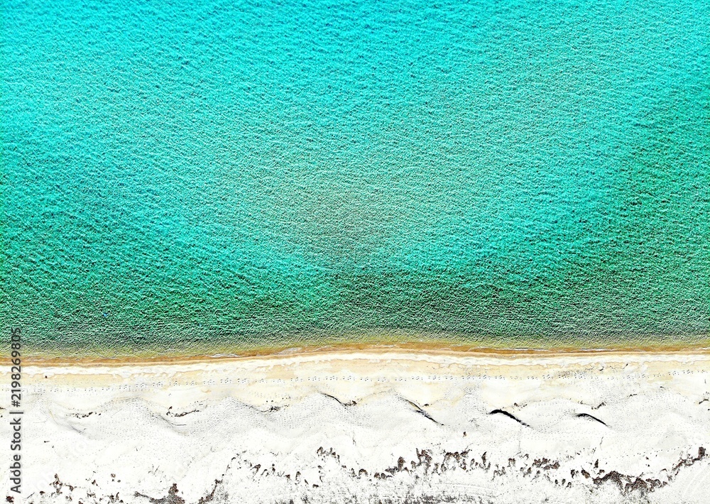 Obraz premium Aerial view of turquoise water meeting white sand beach