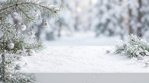 Snow-covered pine branches with frost and fresh snowfall on a blurred winter landscape background